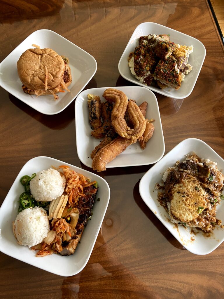 Watson's Counter Lunch Order: Fried Chicken Sandwich (top left corner), Cereal French Toast (top right corner), Churros (middle), KBBQ Pork Plate (bottom left corner), Loco Moco (bottom right corner)